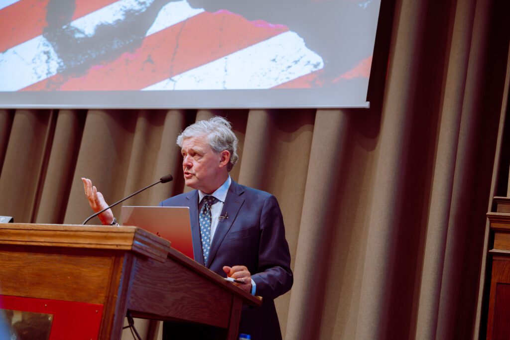 Charles Groenhuijsen achter de katheder tijdens een lezing over Amerika